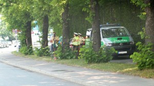 Polizeibus steht auf Radweg neben der Straße, Polizisten haben zwischen Bäumen eine Radarfalle errichtet